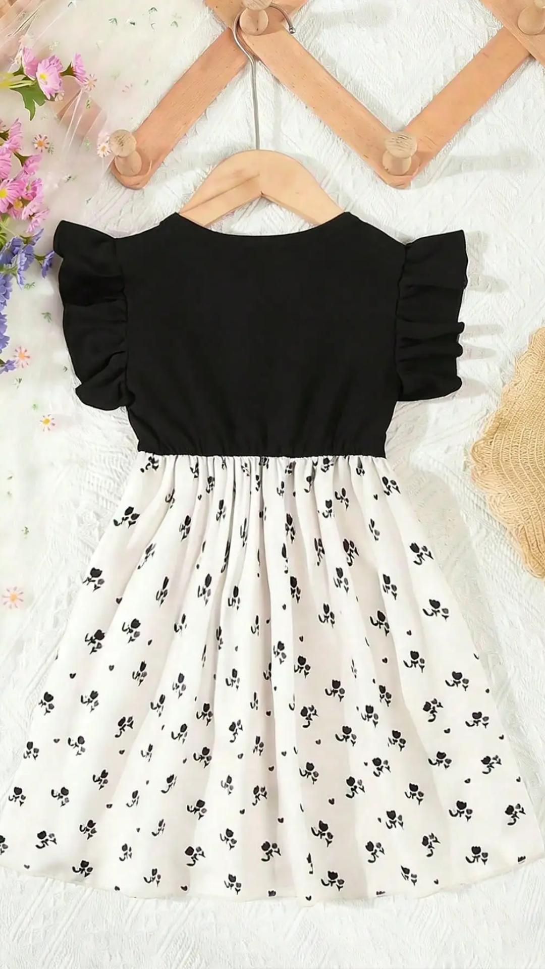 Black top and white skirt with black floral pattern on a white background
