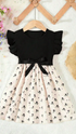 Black top and floral skirt set on a hanger with decorative background