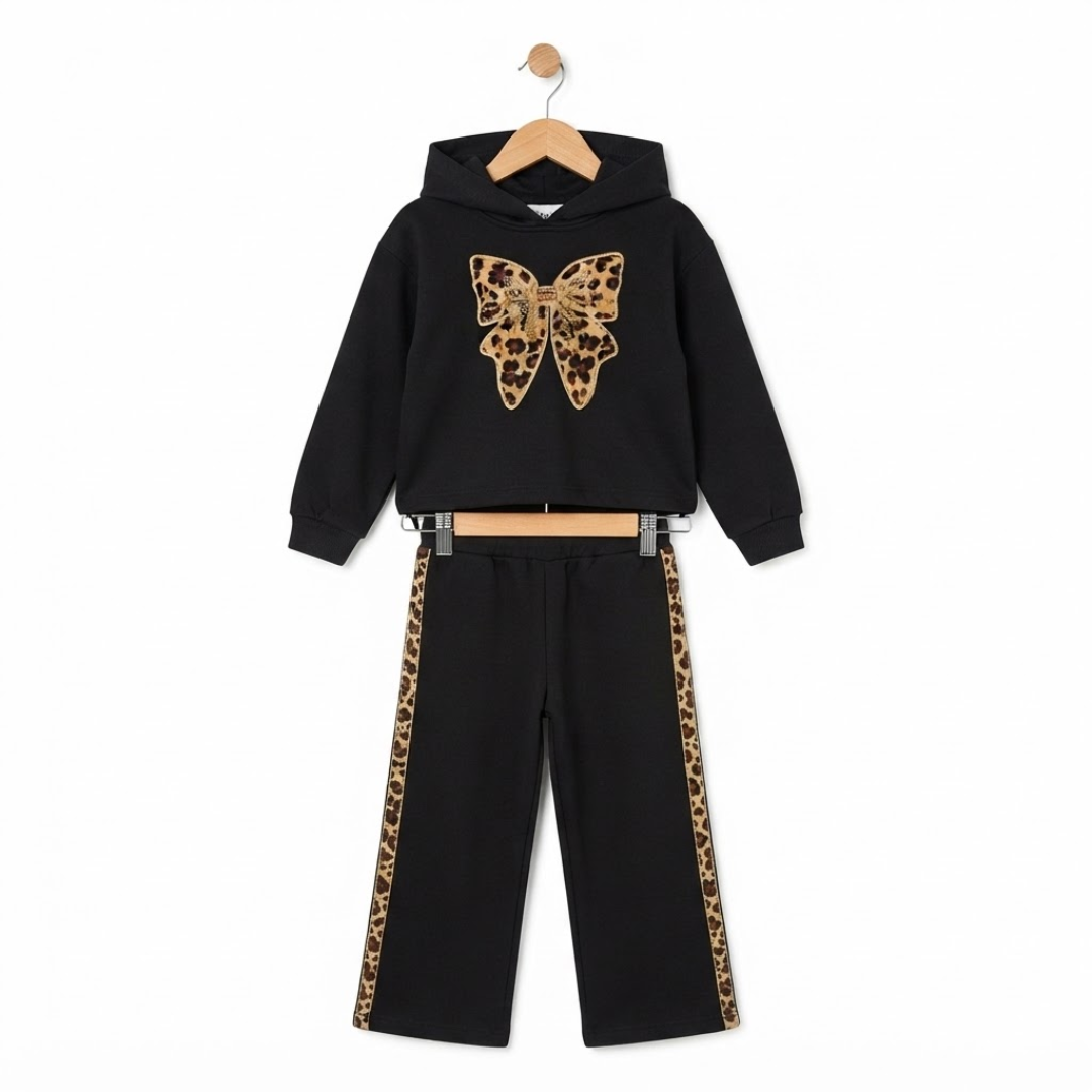A two-piece kids' outfit set consisting of a black cropped hoodie with a leopard-print butterfly graphic on the chest and matching black pants with leopard-print side stripes, displayed on a wooden hanger against a white background.