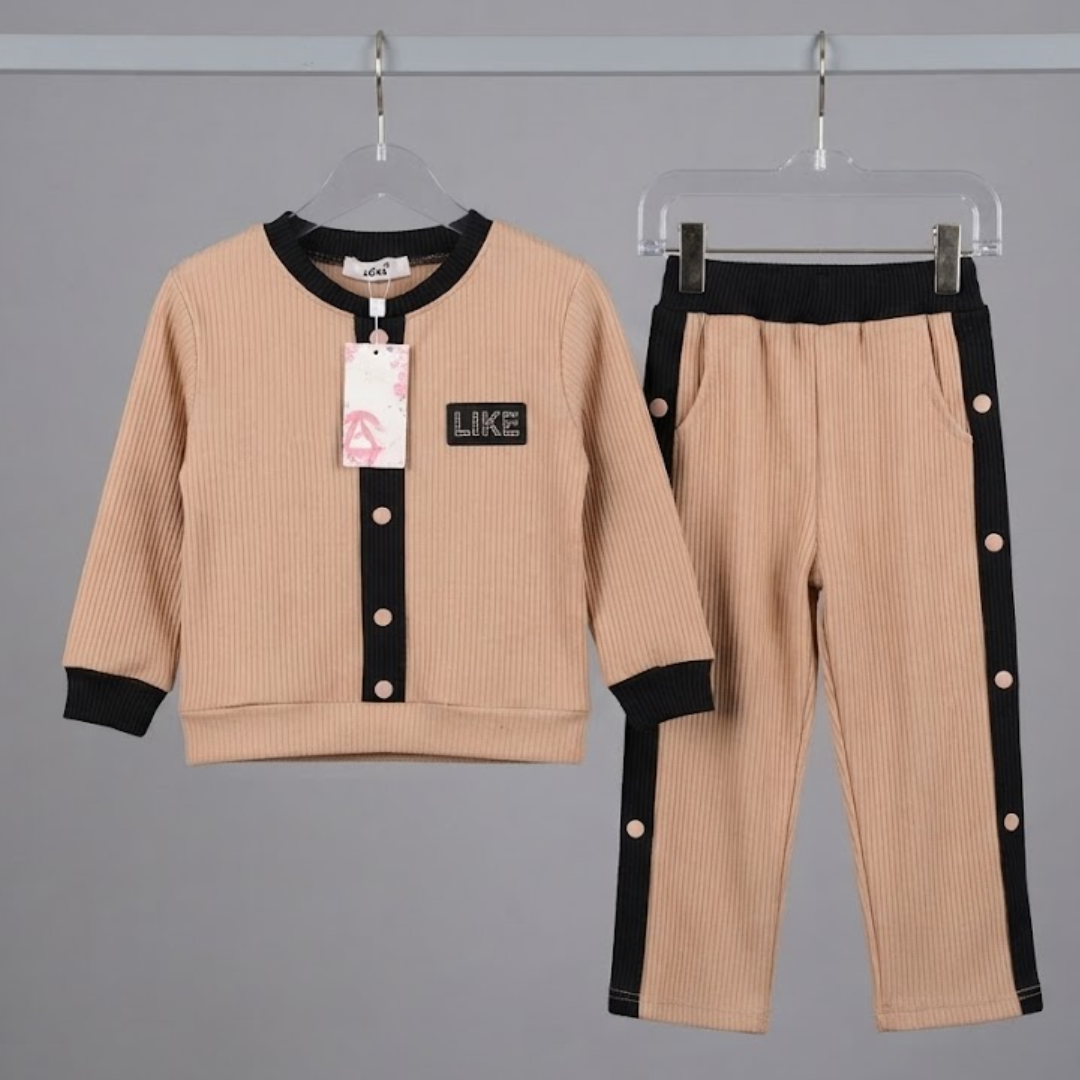 A children's two-piece clothing set displayed on hangers against a gray background, featuring a beige cardigan-style top with black trim and matching beige pants with black side panels.