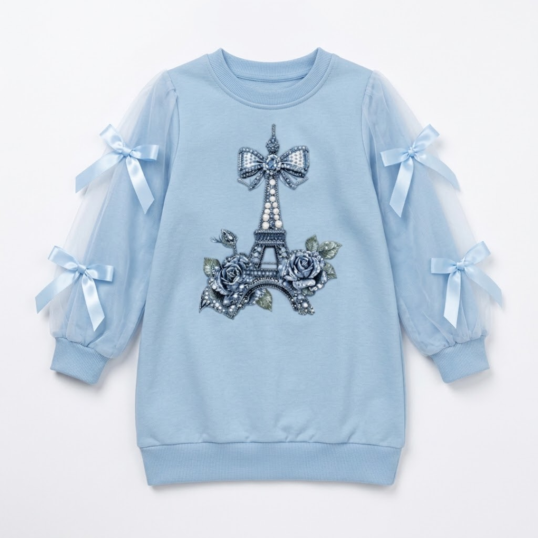 A light blue long-sleeve sweatshirt for girls, featuring a central Eiffel Tower design embellished with rhinestones and roses, and sheer tulle sleeves with light blue ribbon bows.