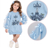 A young girl wearing a light blue long-sleeve dress with sheer tulle sleeves, bow details, and an Eiffel Tower graphic embellished with rhinestones. Two circular inset close-ups on the right show the bow and sleeve bow details.
