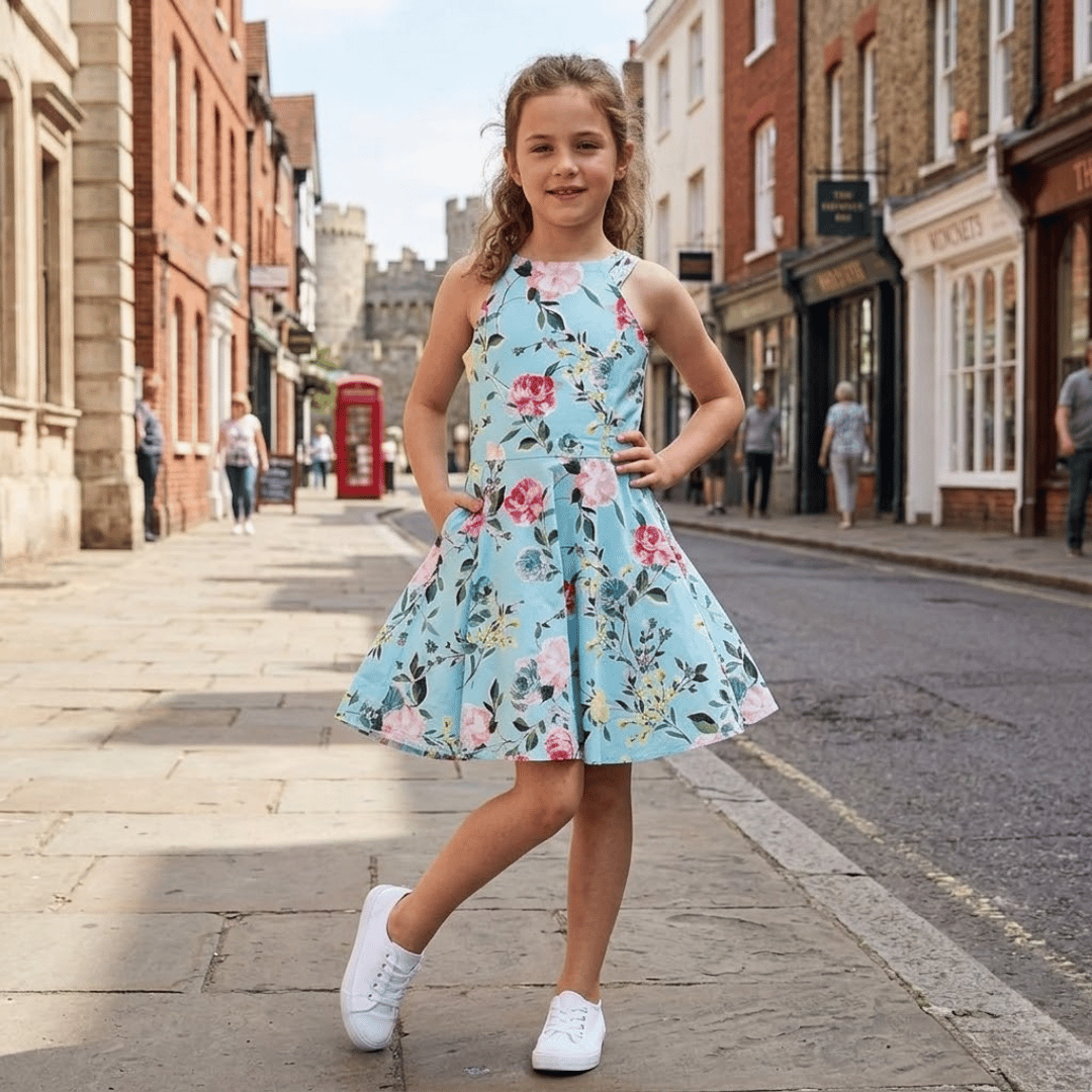 Young girl in a floral dress standing on a city street.