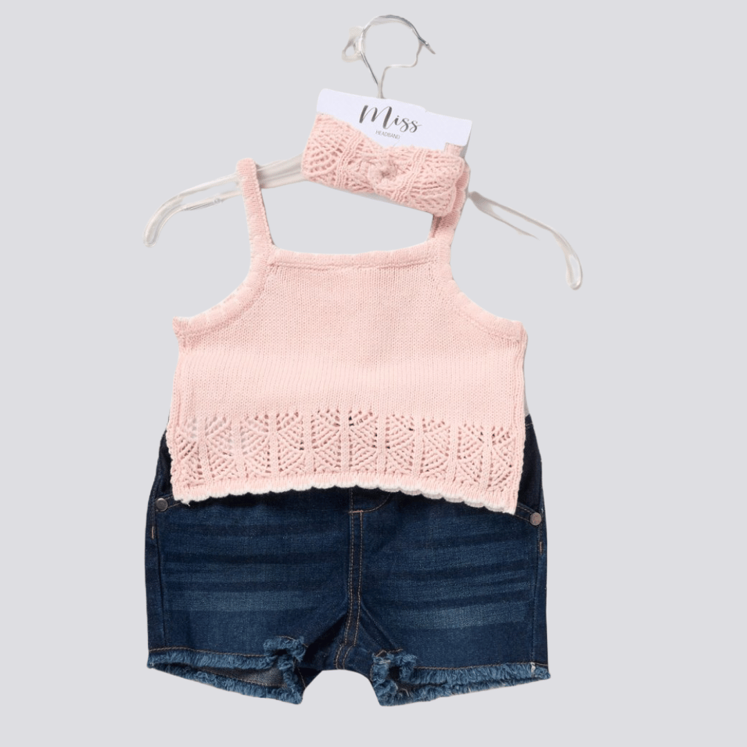 Pink knitted tank top and denim shorts on a hanger with a white background
