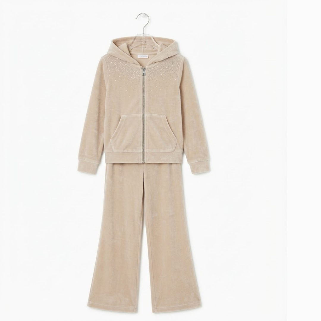 A two-piece children's loungewear set in a soft beige velour fabric, featuring a zip-up hooded sweatshirt and matching wide-leg pants, hanging on a metal hanger against a plain white background.