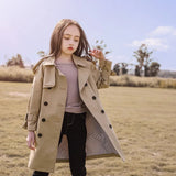 Woman wearing a beige trench coat in an outdoor setting