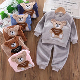 Children's bear-themed sweatshirt and pants set on a wooden surface with additional bear-themed items.