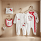 Hello Kitty baby clothing set including onesies, bibs, and a hat on wooden hooks.