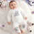 A baby is wearing 2-Piece Elephant Outfit lying on the bed