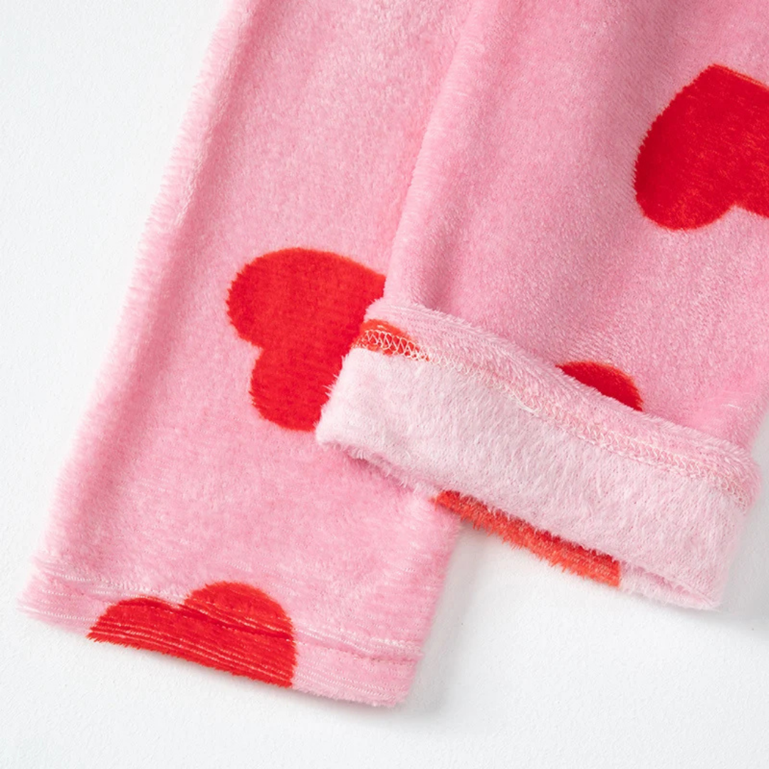 Pink towel with red heart patterns on a white background