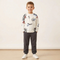 Child wearing a white sweatshirt with colorful graphics and dark pants on a plain background