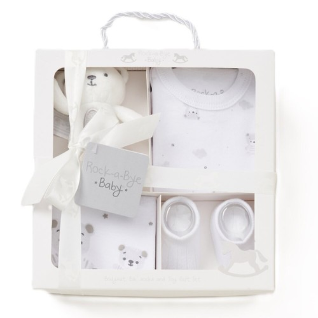 Baby gift set with white teddy bear, clothes, and teether in a box.