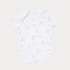 White baby onesie with small print on a light beige background