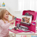 Child playing with a toy hair salon set in a bright room.