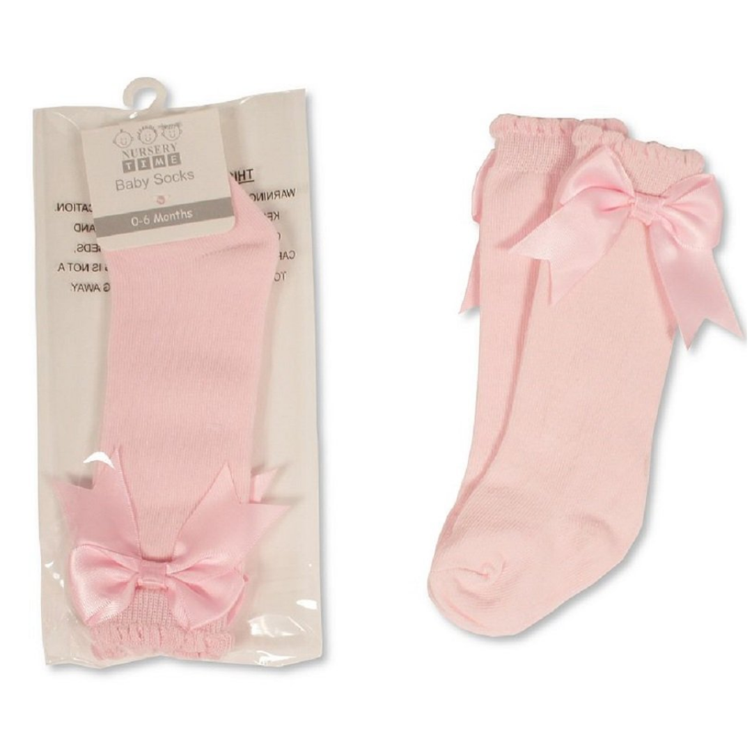 A pair of baby tights in light pink, shown both inside their clear plastic packaging on the left and loose on the right. Each tights features an elasticated top and a large matching satin bow at the ankle.