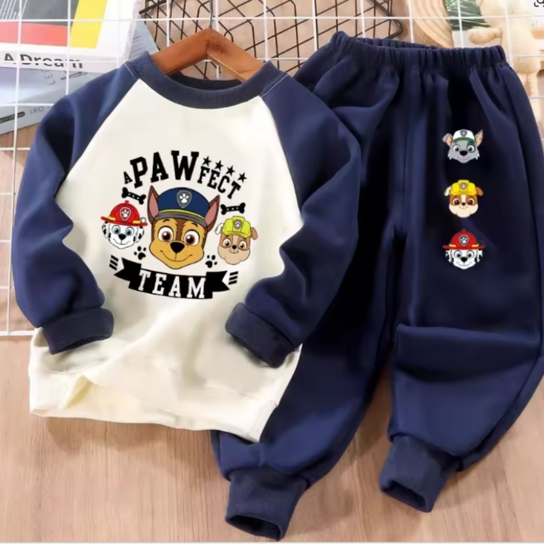 A children's two-piece clothing set featuring a navy blue and cream raglan long-sleeve shirt with a Paw Patrol graphic, paired with matching navy blue pants with character prints.