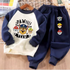 A children's two-piece clothing set featuring a navy blue and cream raglan long-sleeve shirt with a Paw Patrol graphic, paired with matching navy blue pants with character prints.