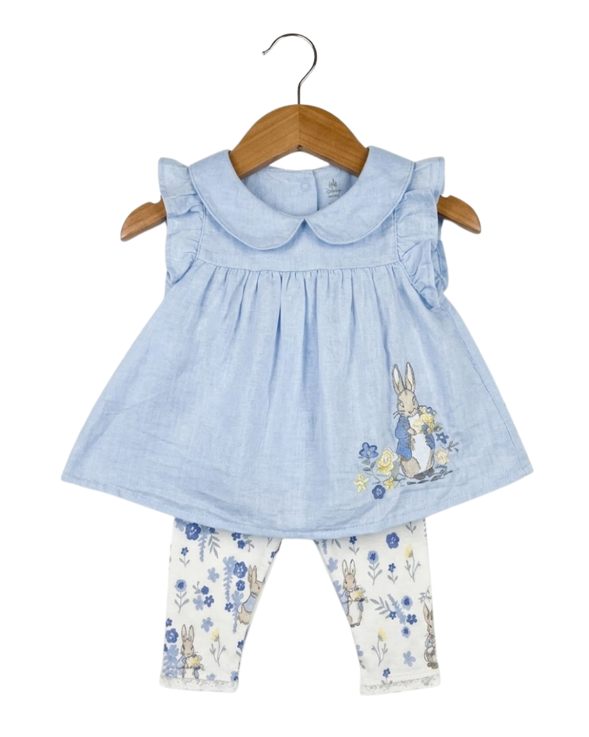 Baby outfit with blue top and floral leggings on a hanger against a white background