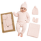 A baby wearing a light pink knit three-piece outfit with a matching beanie, mittens, and blanket, displayed next to its kraft paper packaging box and an additional matching set on a white background.
