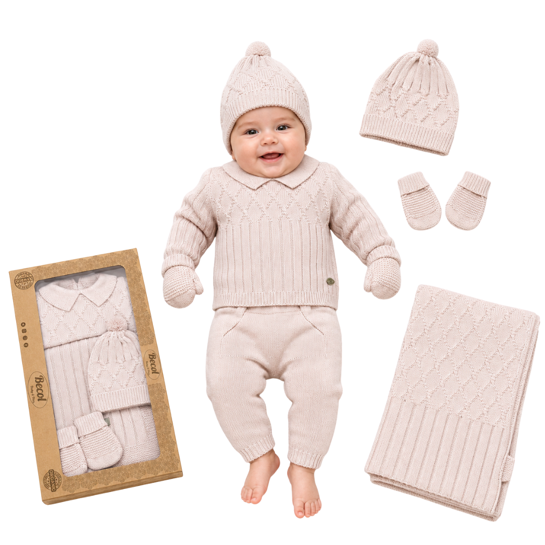 A baby outfit set displayed on a white background, featuring a smiling baby wearing a cream-colored knit sweater, pants, hat, and mittens. Surrounding the baby are the individual pieces, a folded matching blanket, and the product box.