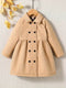 Beige coat with black buttons on a textured beige background