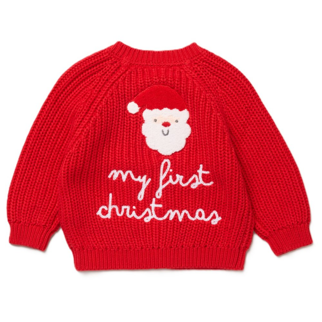 A red knit baby sweater with a white and red Santa face and the words 'my first christmas' knitted on the front, shown against a plain white background.