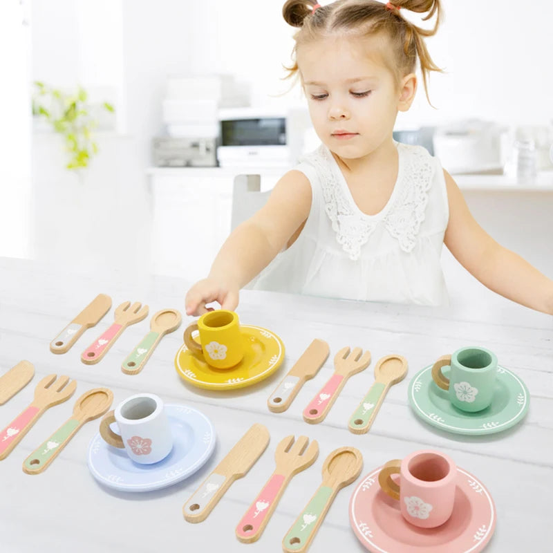 Child playing with a set of colorful toy cups and utensils on a white surface.