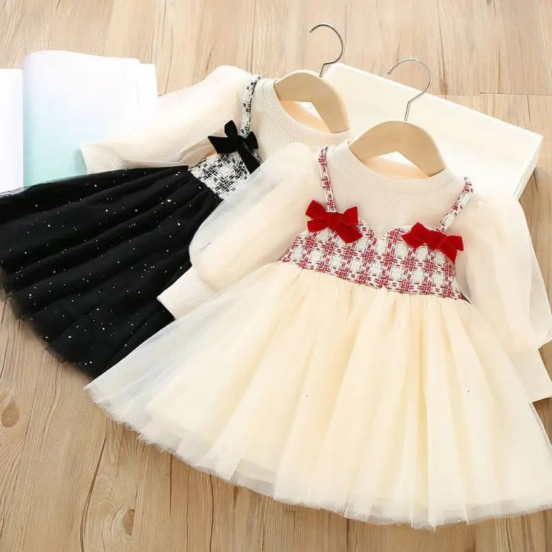 Children's dresses with red bows on a wooden floor