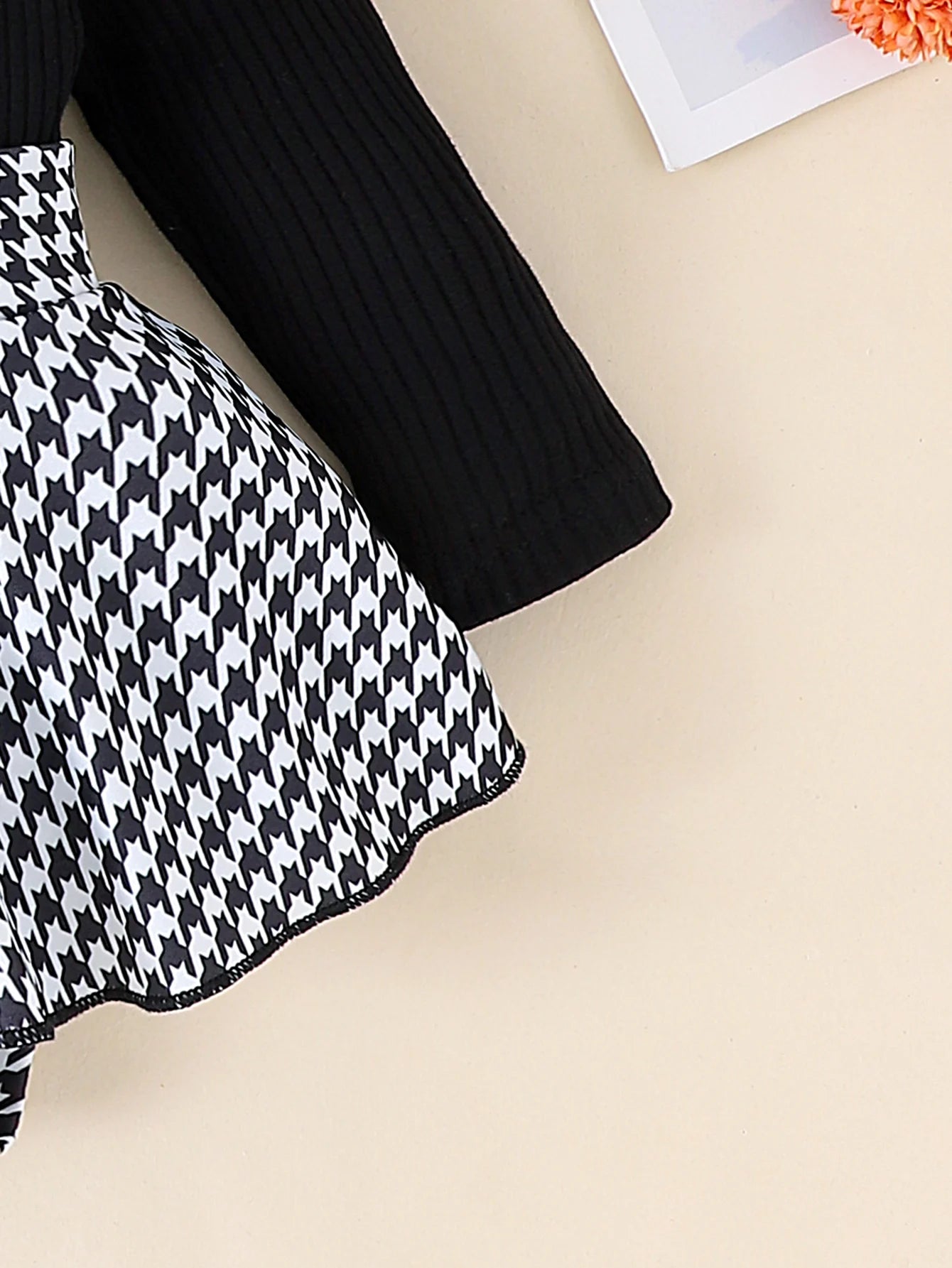 Black and white houndstooth patterned fabric on a beige surface