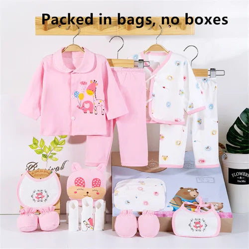 Baby clothing set with pink outfit, white pants, and accessories on hangers against a white background.