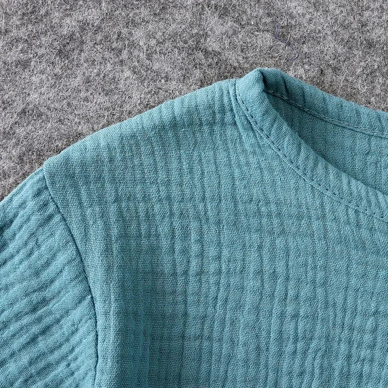 Close-up of a textured teal fabric on a gray surface
