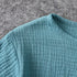Close-up of a textured teal fabric on a gray surface
