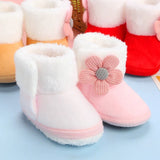 Pink baby boots with a flower design on a light blue background