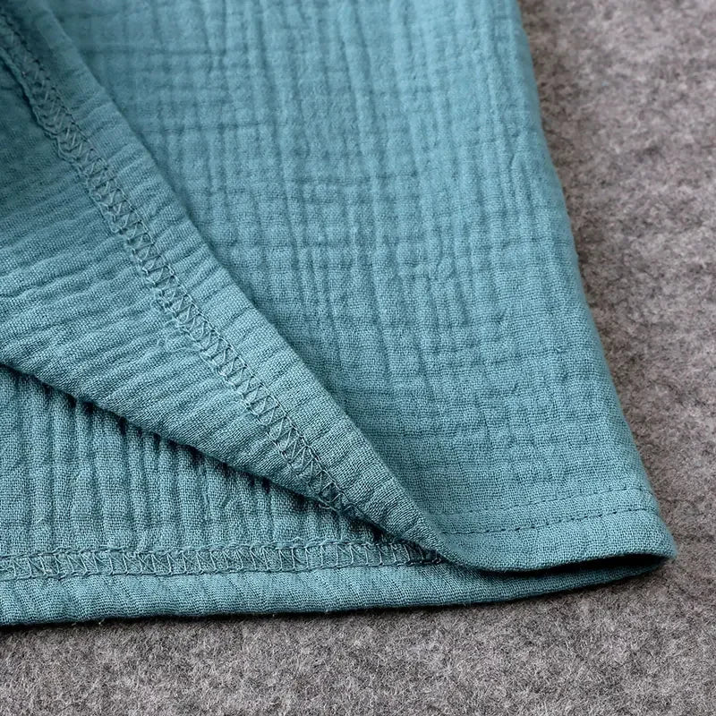 Close-up of teal textured fabric on a gray surface