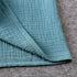 Close-up of teal textured fabric on a gray surface