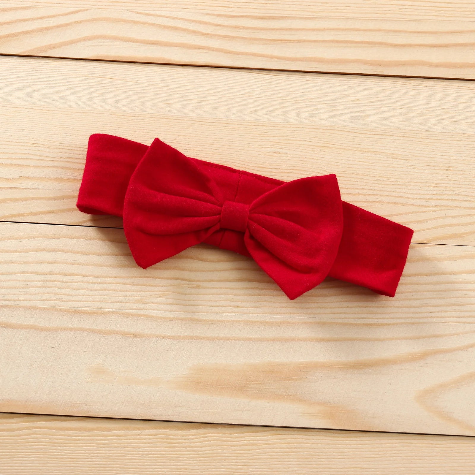 Red bow tie on a wooden surface