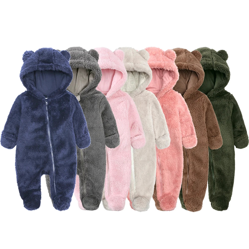Row of colorful baby onesies with bear ears on a white background