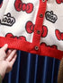 Close-up of a red and white cardigan with Hello Kitty designs.