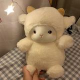 White plush toy resembling a cat held by a hand on a checkered fabric background