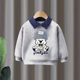 Gray children's sweatshirt with a bear design and text on a hanger against a striped background
