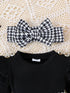 Black and white houndstooth patterned headband on a black top with a lace background