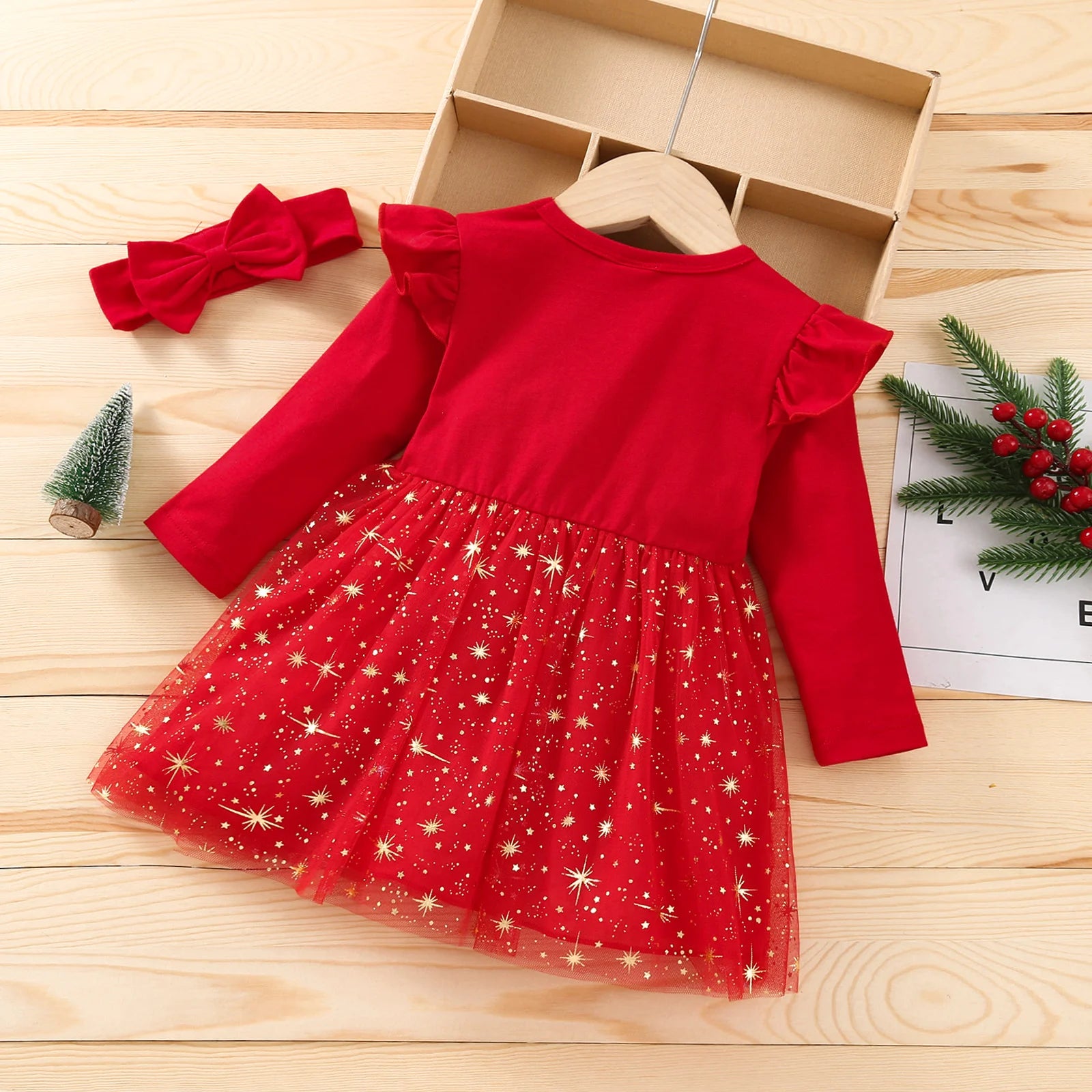 Red dress with star pattern on a wooden surface, accompanied by a matching headband.