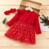 Red dress with star pattern on a wooden surface, accompanied by a matching headband.