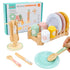 Children's toy dinnerware set with a hand holding a spoon, displayed on a wooden surface.