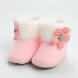 Pink baby boots with a flower design on a light gray background