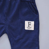 Navy blue pants with a white label featuring the letter 'F' on a light gray background