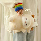 Person holding a plush cat toy with colorful wrist warmers