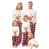Family wearing matching Christmas pajamas with reindeer designs on a white background