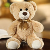 Plush teddy bear with a gold bow tie on a blurred background