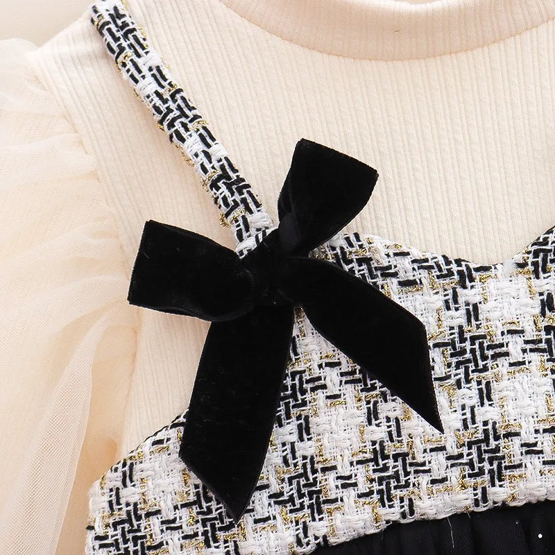 Close-up of a black bow on a patterned top with a beige background